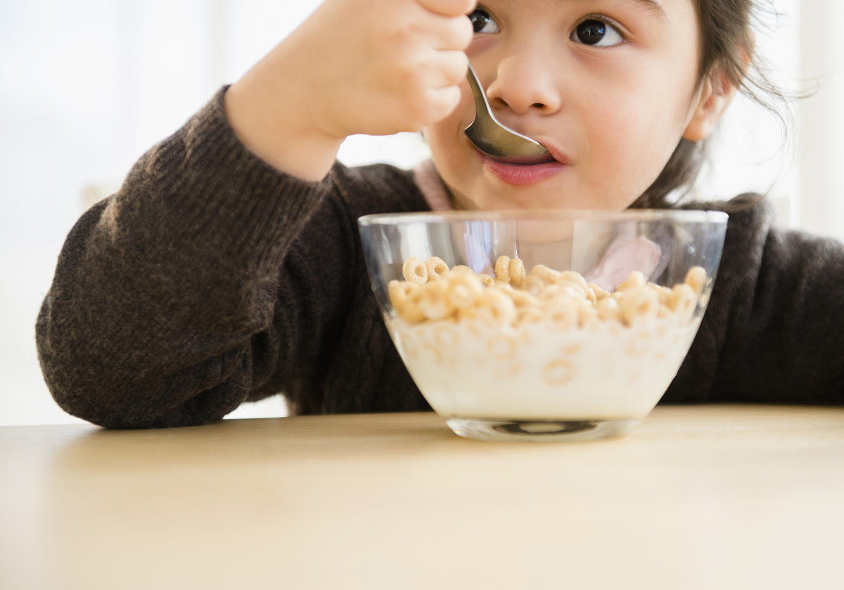 Girl eating cereal from bowl