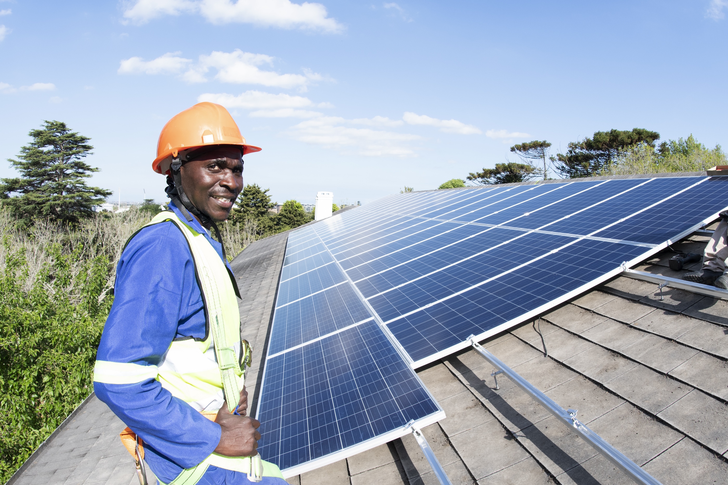 Worker installing solar panels on roof