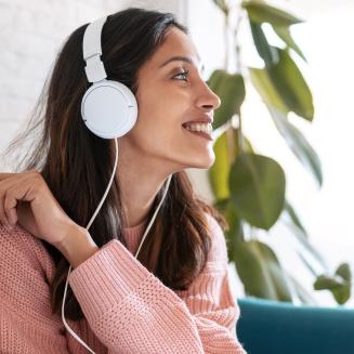woman under headphones listening to Degrees podcast about planet-saving careers