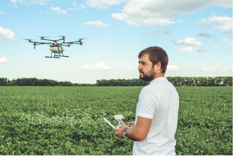 Man operating a drone in a grass field